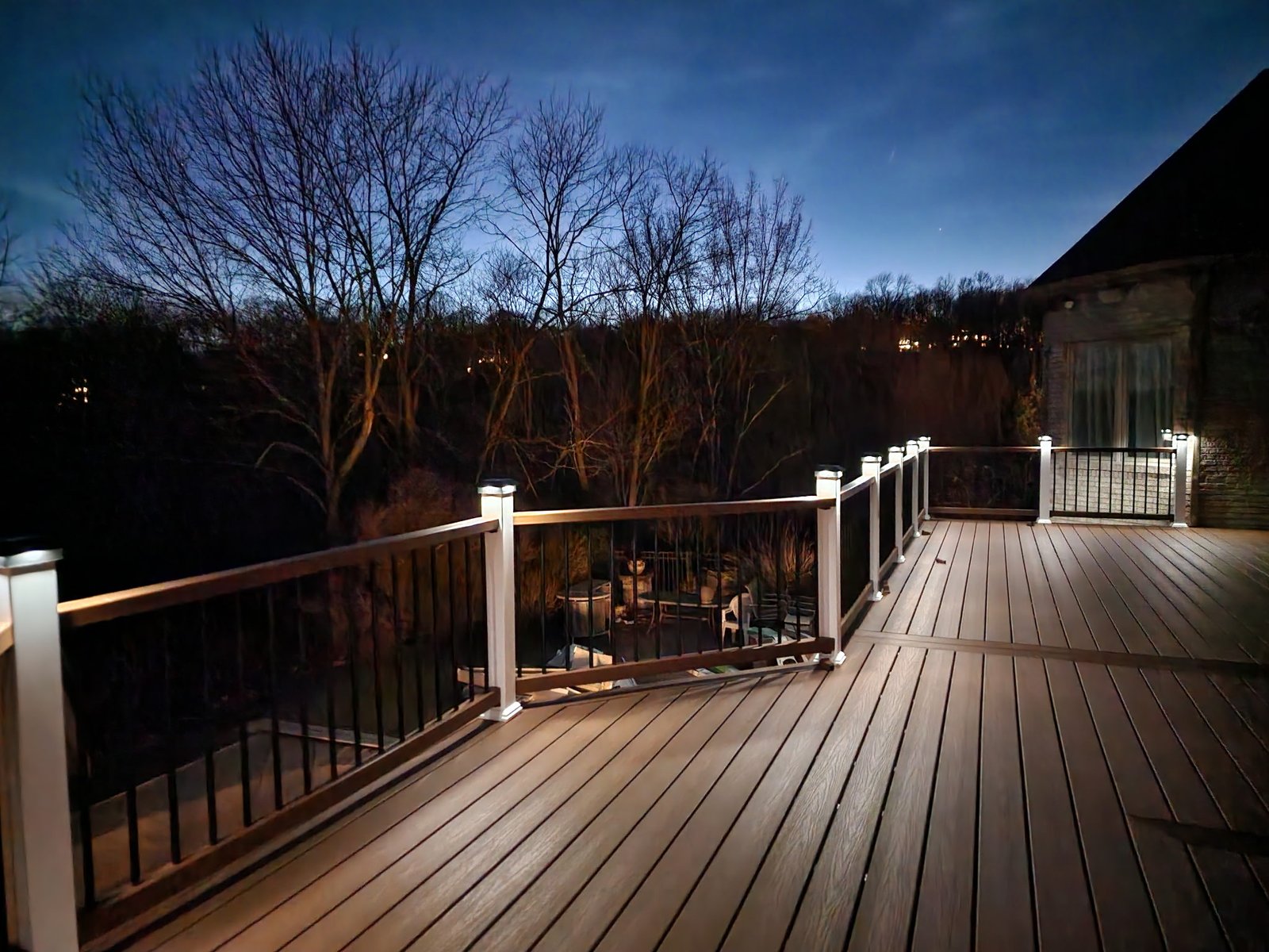 A completed deck with illuminated railing posts at night
